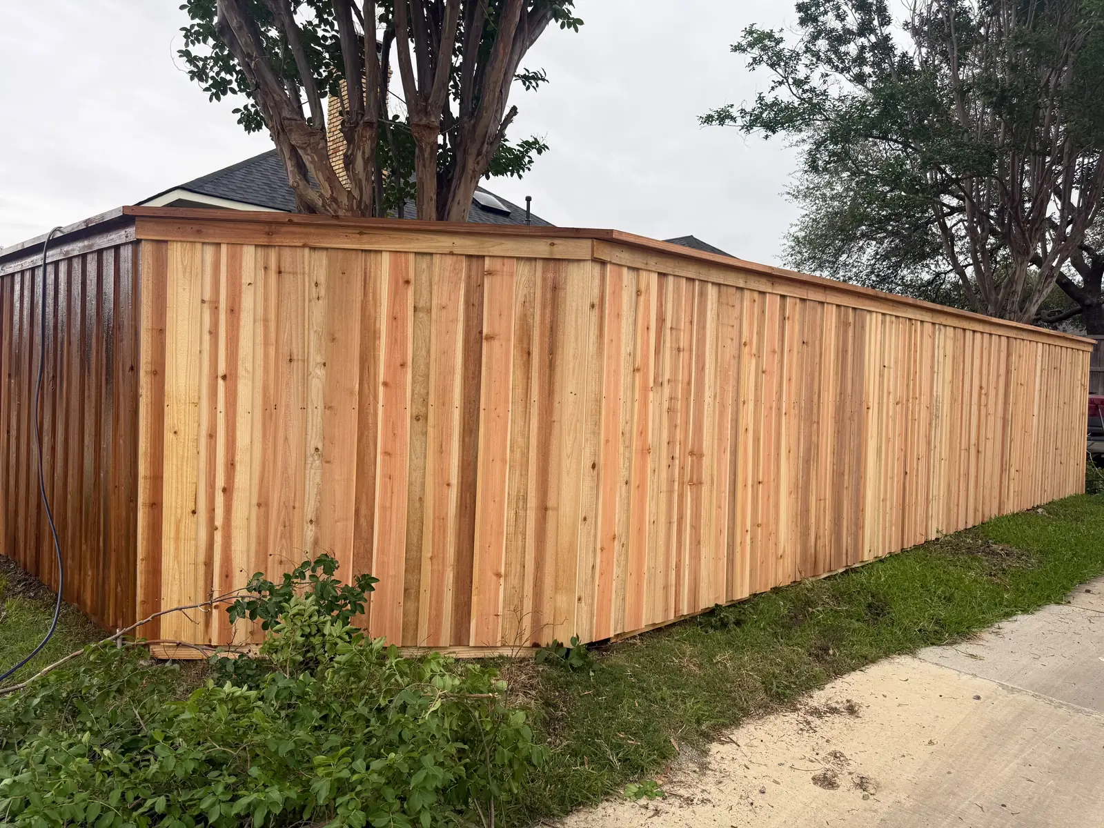 Long run of cedar cap-rail privacy fence